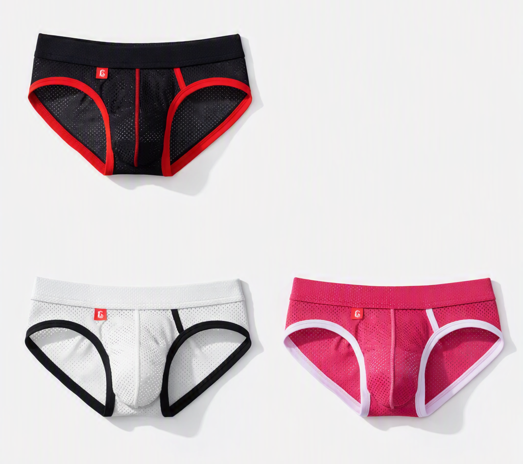 Three pairs of mens briefs arranged on a light gray background: black with red trim at the top left, white with black trim at the bottom left, and pink with white trim at the bottom right. Small red logo tabs are visible on each pair.