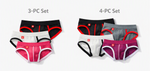 Two sets of mens briefs displayed on a light gray background, labeled '3-PC Set' and '4-PC Set'. The left set contains black, white, and pink briefs with red trim, and the right set contains black, white, and gray briefs with red trim.