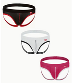 Three pairs of mens mesh briefs shown on a plain light background: one black with red trim, one white with black trim, and one magenta-pink with white trim. Each pair has a small red square logo on the front right side.