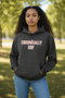 Person wearing black Chronically Gay eco hoodie with bold white text, standing outdoors in relaxed pose