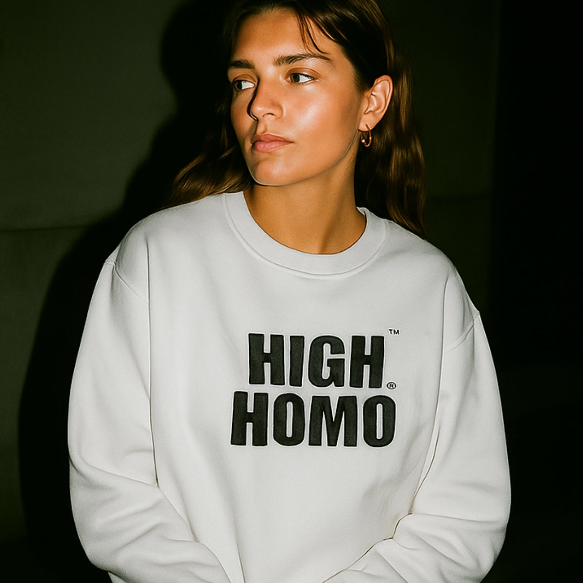 Lesbian-presenting model wearing white HIGH HOMO crewneck, looking off-camera in Chronically Gay campaign banner