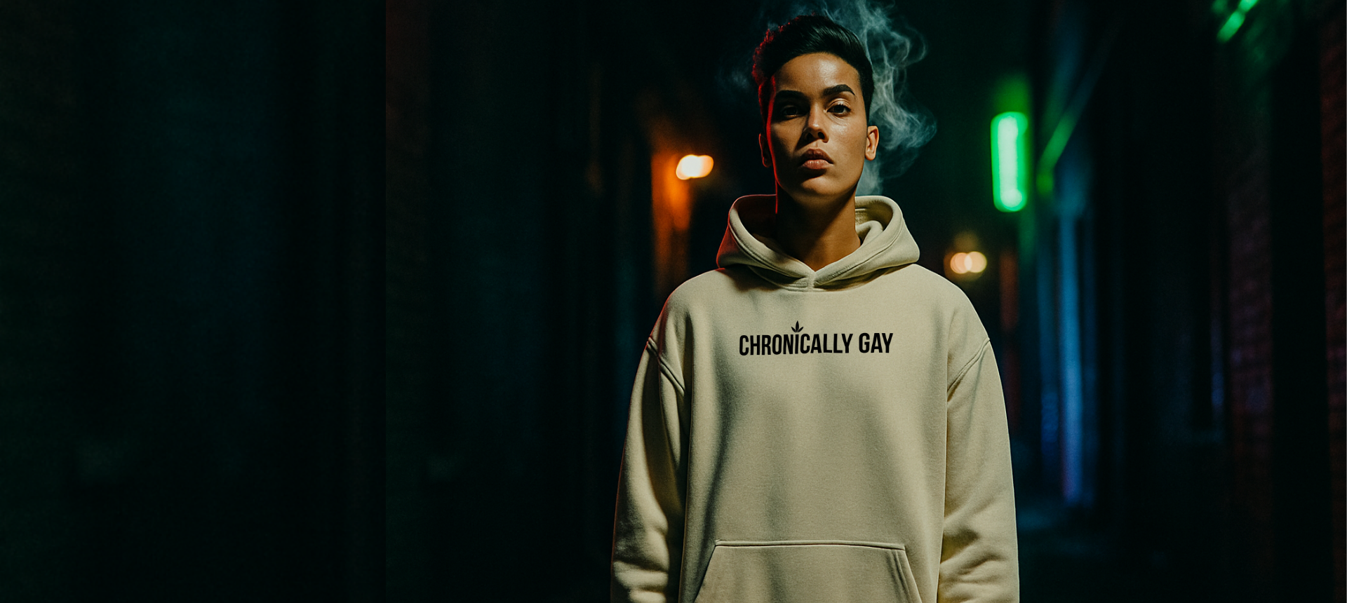 Queer model wearing a “CHRONICLY GAY” hoodie in a moody alleyway, showcasing LGBTQ streetwear.