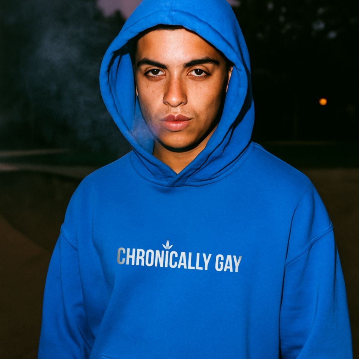 Queer model in Chronically Gay blue hoodie, front-facing portrait