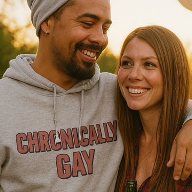 Man wearing CHRONICALLY GAY hoodie standing next to woman outdoors, featured in Chronically Gay testimonial section.