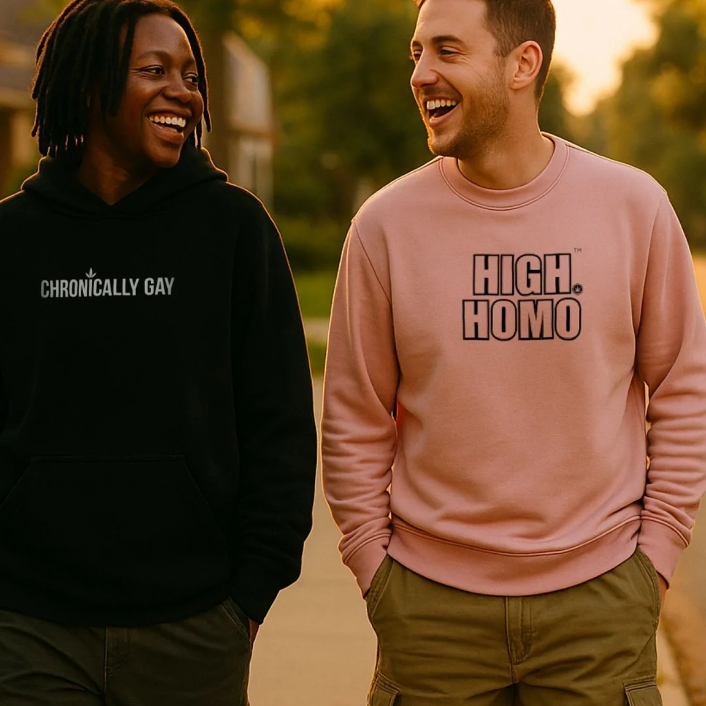 Two people wearing black and pink Chronically Gay hoodies, standing outdoors in queer fashion campaign
