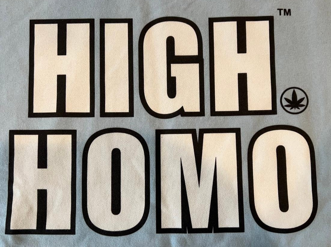 Bold “HIGH HOMO™” text outlined in black on light blue fabric, with cannabis leaf icon next to HOMO